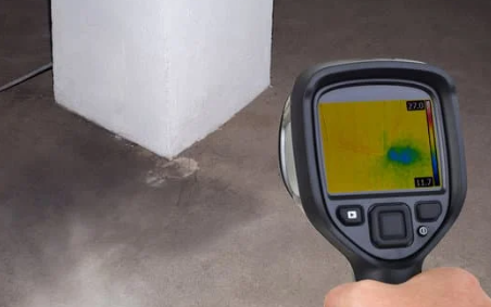 Thermographer using an infrared camera to inspect electrical equipment